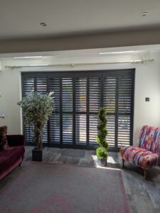 Anthracite Hardwood Shutters Fitted On A Track Over Bi Fold Doors in Wilmslow
